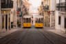 Yellow tram on a cobbled street in Lisbon